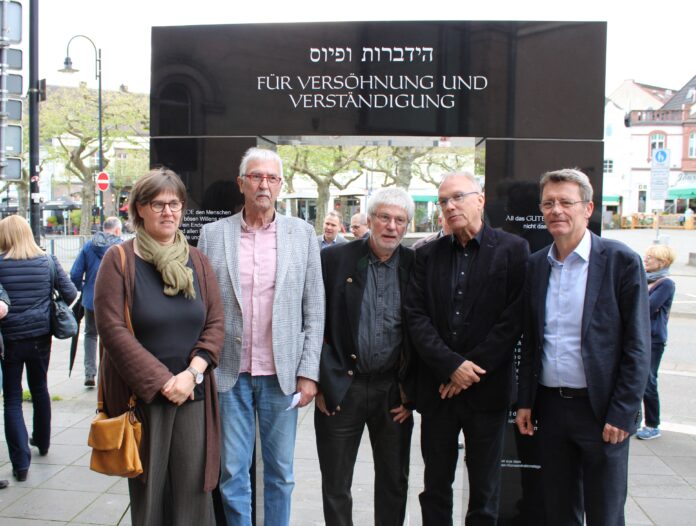 Pfarrerin Gabriele Kräuter (Ev. Kirchengemeinde St. Wendel-Illtal), Eberhard Wagner (Verein „Wider das Vergessen“), Bildhauer Gerd Kraushaar, Landrat Udo Recktenwald und Bürgermeister Peter Klär vor dem neuen Gedenktor - Foto: evks/Eulenstein