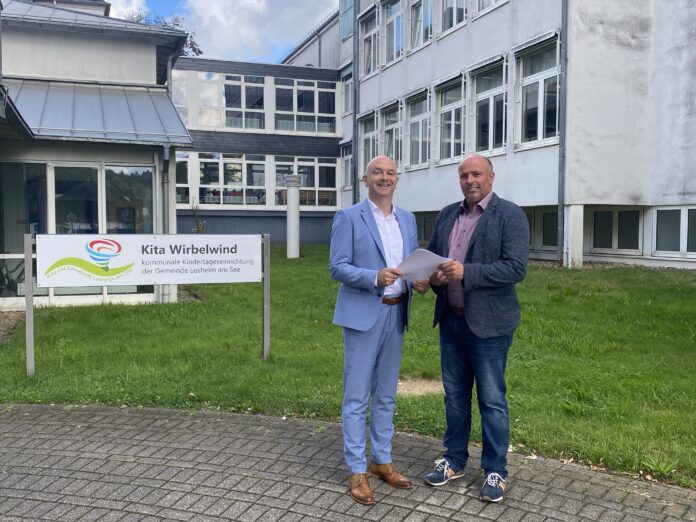 Alexander Schuhler, Geschäftsführer Marienhaus GmbH (links im Bild) mit Stefan Palm, Erster Beigeordneter der Gemeinde Losheim am See, bei der Vertragsunterzeichung vor dem Krankenhausgebäude in Losheim. Foto: Astrid Härtel / Gemeinde