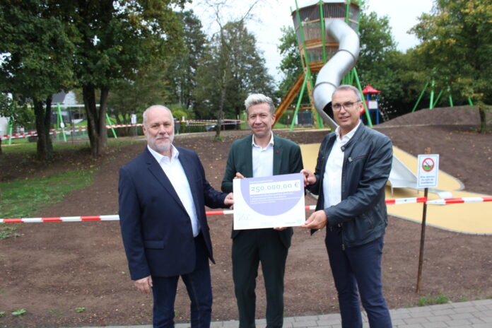 Staatssekretär Sebastian Thul (M.) übergibt dem Bürgermeister der Gemeinde Oberthal, Stephan Rausch (r.), und dem Ortsvorsteher von Oberthal, Reiner Burkholz (l.), einen Zuwendungsbescheid in Höhe von 250.000 Euro, Foto: MUKMAV/David Cuervo Müller