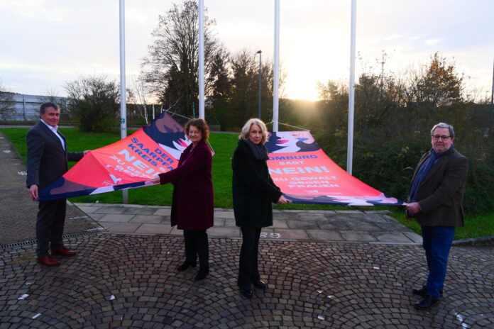 Landrat Dr. Theophil Gallo, die Frauenbeauftragten Birgit Rudolf und Anke Michalsky sowie der Beigeordnete Manfred Rippel (v. l.) präsentierten die Aktions-Fahnen. Foto: Sandra Brettar