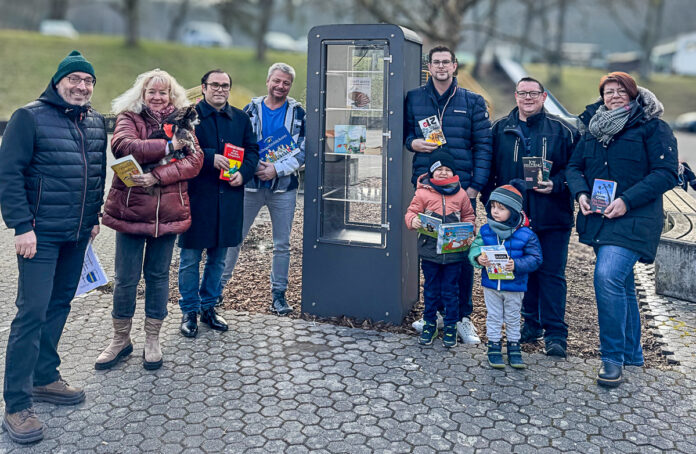 Ortsvorsteher Stefan Paulus, Ehrenamtlerin Claudia Laval-Armand, Ortsratsmitglieder Andreas Schneider-Michel, Ulrich Schick, Benjamin Backes, Christian Wilhelm, Candi Guckelmus und viele Kinder und freuen sich über die Eröffnung des Bücherschranks und stiften selbst erste Bücher. Foto: Nadine Backes